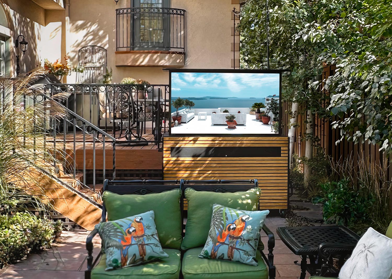 Patio with raised outdoor TV and green seating area