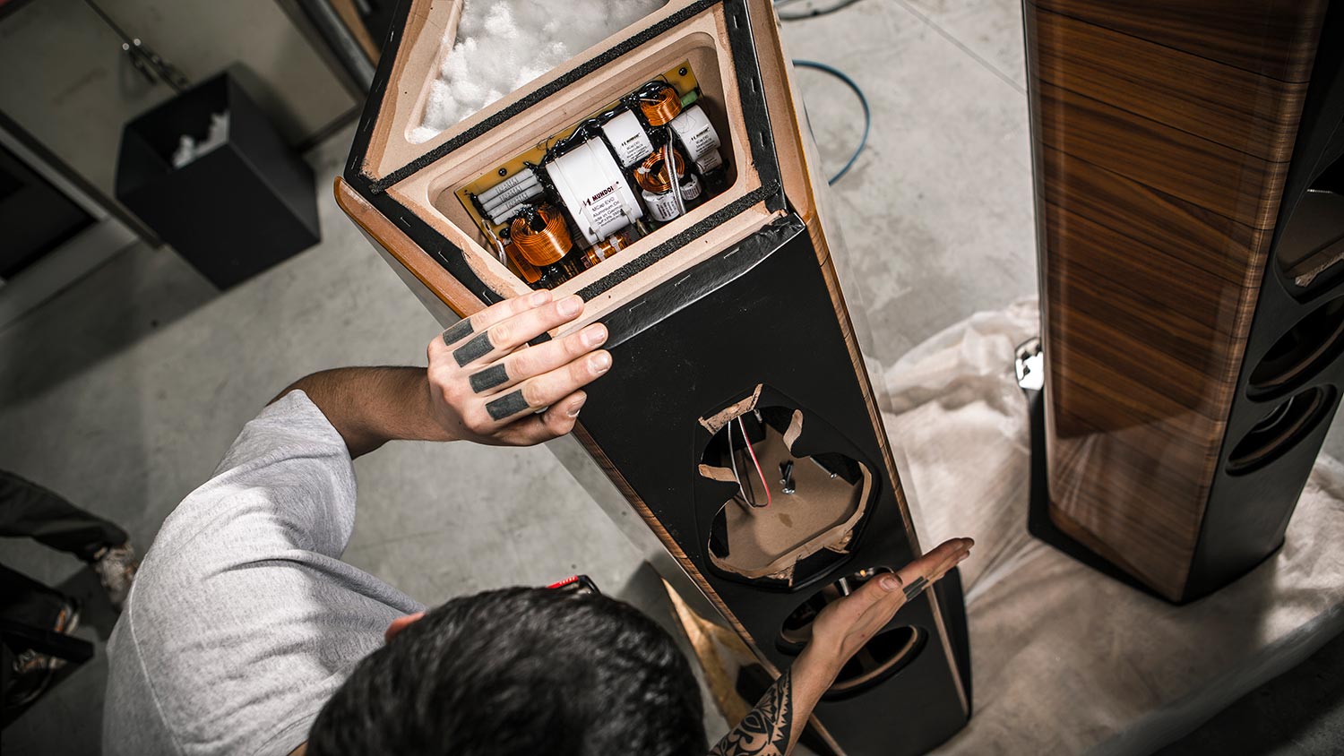 Open speaker cabinet showing internal components during assembly