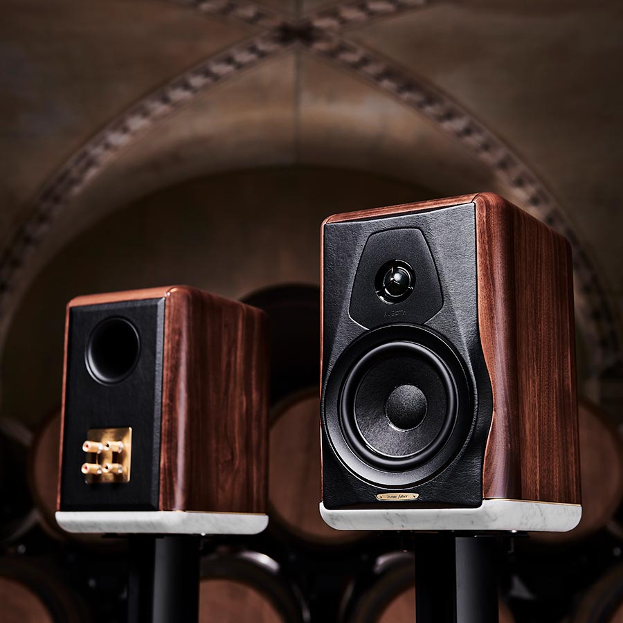 Compact bookshelf speakers on stands with wood cabinets and marble bases