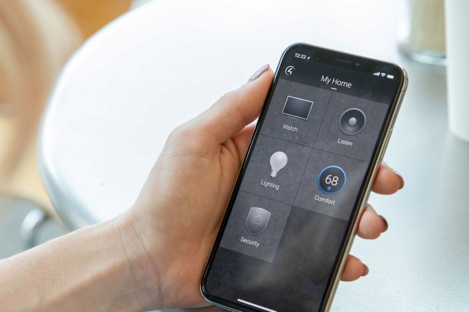 Person holding iphone with Control4 interface on it