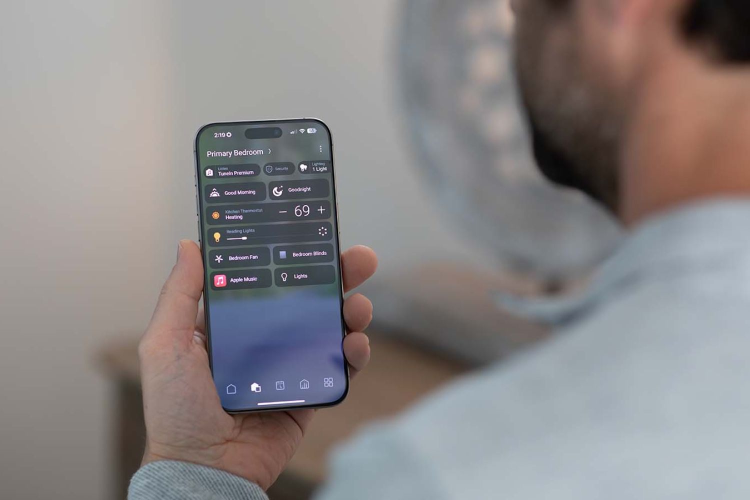 Person holding iphone with Control4 interface on it