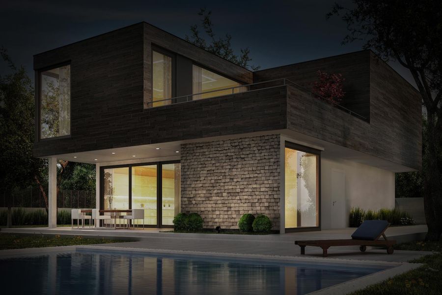 Contemporary house with warm exterior lighting and pool reflection at night