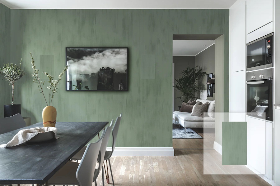 A modern dining and kitchen area in an Atlanta home showcases a multiroom audio setup with nearly invisible speakers on a green wall.