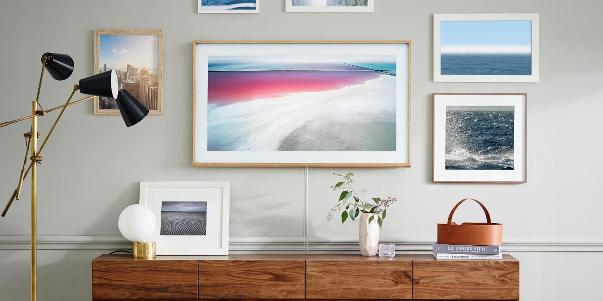 Samsung Frame TV over wooden desk, gallery wall