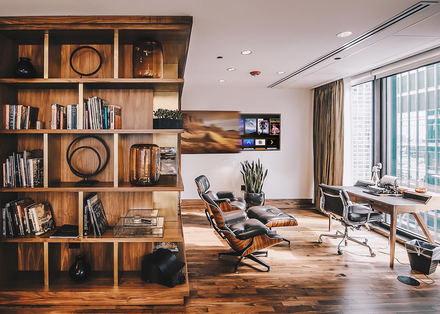 Home office with wood shelving and lounge chair near window